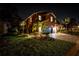 Night view of two-story house with palm trees and well-lit landscaping at 3831 Evergreen Oaks Dr, Lutz, FL 33558