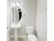 Clean and modern bathroom with pedestal sink, toilet, and oval mirror at 3831 Evergreen Oaks Dr, Lutz, FL 33558