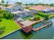 Stunning aerial view of a waterfront home with a private dock, boat lift, screened pool, and lush landscaping at 5510 E Longboat Blvd, Tampa, FL 33615
