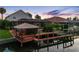 Relaxing backyard featuring a covered deck, private dock, and tranquil waterfront views at 5510 E Longboat Blvd, Tampa, FL 33615