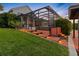 Lush backyard with a screened patio, wooden stairs and outdoor lights at 5510 E Longboat Blvd, Tampa, FL 33615