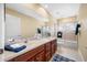 Bright bathroom featuring a double sink vanity, bathtub with glass doors and tiled walls at 5510 E Longboat Blvd, Tampa, FL 33615