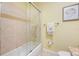 Clean bathroom featuring tile walls, a shower-tub combo with a glass door, and a granite countertop at 5510 E Longboat Blvd, Tampa, FL 33615