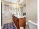Bathroom featuring a double sink vanity, large mirror, and a blue geometric patterned rug at 5510 E Longboat Blvd, Tampa, FL 33615