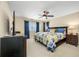 Spacious bedroom featuring a ceiling fan, TV, and comfortable bed with a colorful quilt at 5510 E Longboat Blvd, Tampa, FL 33615