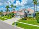 Charming two-story home featuring a three-car garage, well-manicured lawn, and mature palm trees at 5510 E Longboat Blvd, Tampa, FL 33615