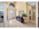 Elegant foyer with high ceilings, tile flooring, a decorative console table and a view to the formal living area at 5510 E Longboat Blvd, Tampa, FL 33615