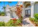Inviting front entrance featuring a beautiful double door, manicured landscaping, and a spacious three-car garage at 5510 E Longboat Blvd, Tampa, FL 33615