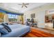 Bright main bedroom featuring hardwood floors, a tray ceiling, a bay window and access to the ensuite bath and kitchen at 5510 E Longboat Blvd, Tampa, FL 33615