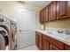 Bright laundry room with washer, dryer, cabinets, and utility sink at 5510 E Longboat Blvd, Tampa, FL 33615