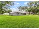 Spacious backyard showcasing the home's exterior and ample green space at 11734 Orange Ct, Dade City, FL 33525