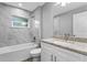 Bright bathroom featuring a granite vanity top, shower and tub with tiled walls and a framed mirror at 11734 Orange Ct, Dade City, FL 33525