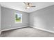 This bedroom features neutral walls, a ceiling fan, base molding, and a window providing natural light at 11734 Orange Ct, Dade City, FL 33525