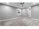 This bedroom features neutral walls, a ceiling fan, base molding, and a window providing natural light at 11734 Orange Ct, Dade City, FL 33525