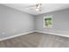 This bedroom features neutral walls, a ceiling fan, base molding, and a window providing natural light at 11734 Orange Ct, Dade City, FL 33525