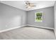 This bedroom features neutral walls, a ceiling fan, base molding, and a window providing natural light at 11734 Orange Ct, Dade City, FL 33525