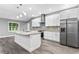 Bright kitchen featuring a center island, stainless steel appliances, gray floors and white cabinets at 11734 Orange Ct, Dade City, FL 33525