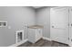 Laundry room with granite countertop and white cabinets, contrasting well with the dark flooring at 11734 Orange Ct, Dade City, FL 33525