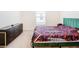 Bedroom with green velvet bed and dark dresser at 13292 Golden Lime Ave, Spring Hill, FL 34609