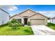 Tan one-story house with two-car garage and landscaping at 13292 Golden Lime Ave, Spring Hill, FL 34609