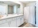Bathroom with double vanity, shower, and striped shower curtain at 13292 Golden Lime Ave, Spring Hill, FL 34609