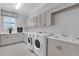 Bright laundry room with shaker cabinets and a utility sink at 15908 Castle Park Ter, Lakewood Ranch, FL 34202