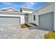 White two-car garage with gray doors and a brick driveway at 8328 Golden Beach Ct, Parrish, FL 34219