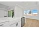 Modern kitchen features a farmhouse sink, stainless steel dishwasher, and white cabinetry at 8328 Golden Beach Ct, Parrish, FL 34219
