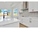 Modern kitchen with white cabinets, island, and stainless steel appliances at 8328 Golden Beach Ct, Parrish, FL 34219