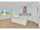 Modern kitchen with white cabinets, island, and stainless steel appliances at 8328 Golden Beach Ct, Parrish, FL 34219