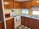Kitchen area with stove, microwave and wood cabinets at 39047 Ola Ave, Zephyrhills, FL 33542