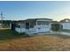 Mobile home exterior features a carport and well-maintained lawn at 39047 Ola Ave, Zephyrhills, FL 33542