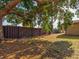 Partially shaded backyard with a brown privacy fence and mature trees at 1810 Haverford Ave, Sun City Center, FL 33573