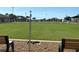 Expansive lawn bowling green with benches and a center pole at 1810 Haverford Ave, Sun City Center, FL 33573