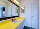 Bathroom with yellow vanity and a large mirror at 1810 Haverford Ave, Sun City Center, FL 33573