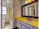 Bright bathroom with yellow vanity and large mirror at 1810 Haverford Ave, Sun City Center, FL 33573
