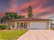 House exterior featuring a two-car garage and manicured lawn at 1810 Haverford Ave, Sun City Center, FL 33573