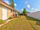 Spacious backyard with a large grassy area, privacy fence, and mature plants at 1810 Haverford Ave, Sun City Center, FL 33573