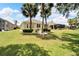 House with backyard, palm trees and grassy area at 1013 Emerald Dunes Dr, Sun City Center, FL 33573