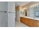 Double vanity bathroom with wood cabinets and a large mirror at 1013 Emerald Dunes Dr, Sun City Center, FL 33573