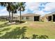 House with backyard, palm trees and grassy area at 1013 Emerald Dunes Dr, Sun City Center, FL 33573