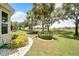 Landscaped backyard with lush greenery and a view of the golf course at 1013 Emerald Dunes Dr, Sun City Center, FL 33573