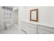 Bathroom offers white cabinets and a basket weave framed mirror above the sink at 386 Club Manor Dr, Sun City Center, FL 33573