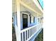 Charming front porch with white railing and black front door at 1703 Mobile Ave, Tampa, FL 33610