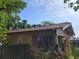 Yellow house with a rustic roof, front porch, and mature trees at 2607 E 26Th Ave, Tampa, FL 33605