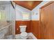 Updated bathroom with a walk-in shower, toilet and wood-paneled walls at 2716 N Jefferson St, Tampa, FL 33602