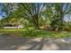 Residential lot with mature trees, and a home in the background at 7207 Westinghouse Ave, Tampa, FL 33619