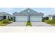 Two-car garage home with light blue exterior and landscaping at 12706 Palatka Dr, Venice, FL 34293