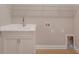 Laundry room with white cabinets and a utility sink at 12706 Palatka Dr, Venice, FL 34293