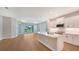 Open concept kitchen with island, white cabinets and view to backyard at 12706 Palatka Dr, Venice, FL 34293